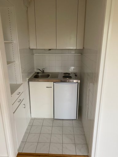 Küchennische mit der kleinen Kompaktküche und dem eingebauten Schrank an der linken Seite
